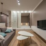 Een wit houten tv-meubel in een moderne woonkamer, gecombineerd met diverse accessoires en kleuren voor een frisse uitstraling.